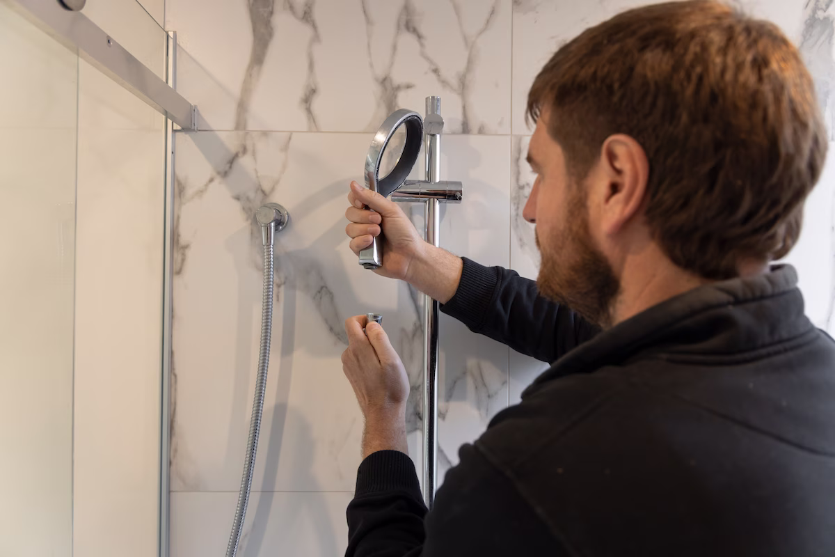 A Foleys worker installing and fixing shower head